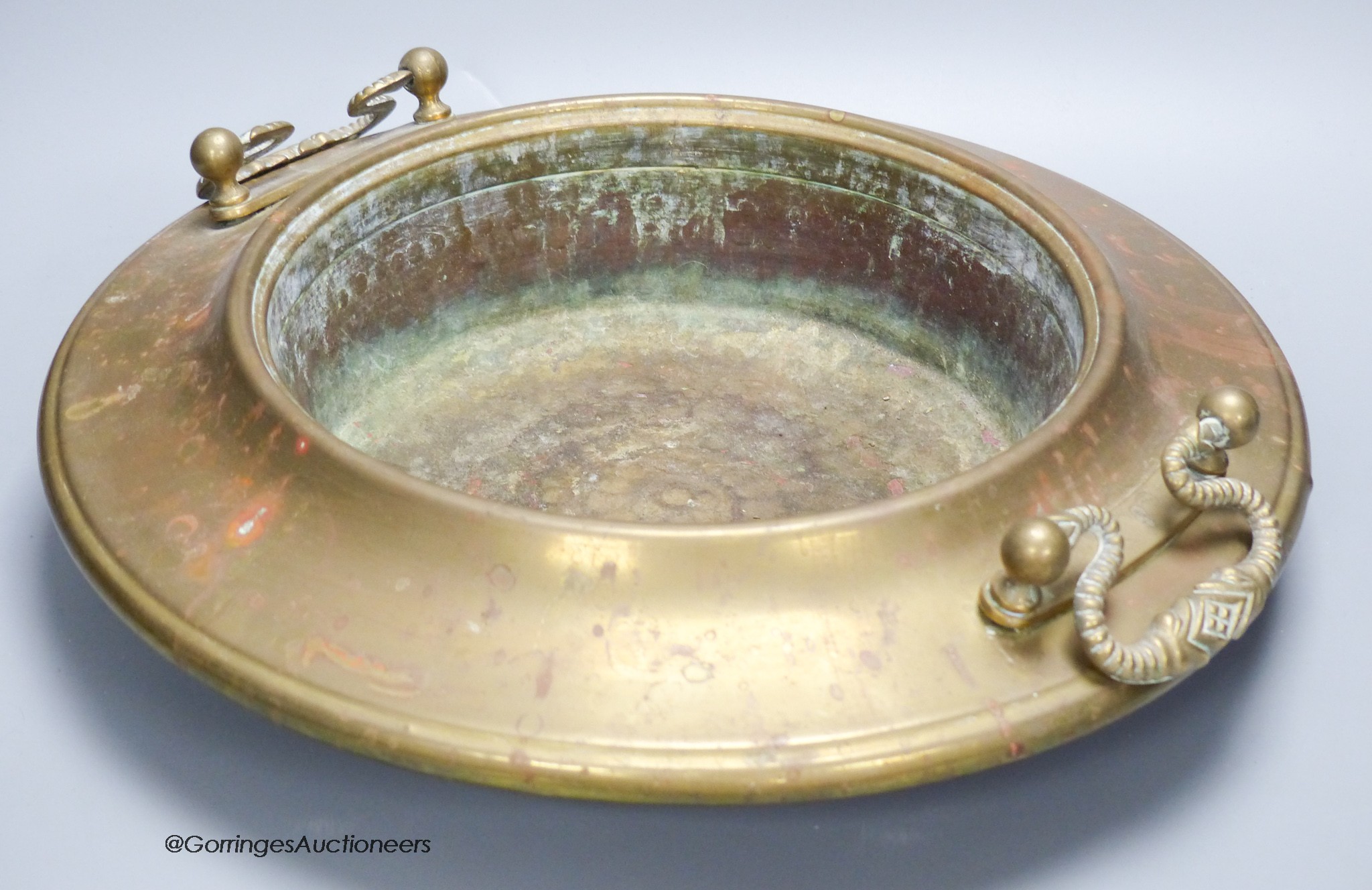 A circular brass two handled bowl, diameter 38cm